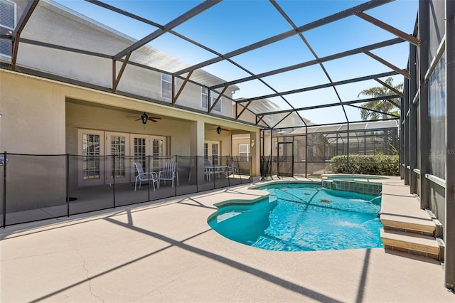 view of swimming pool with french doors, a pool with connected hot tub, a ceiling fan, glass enclosure, and a patio area