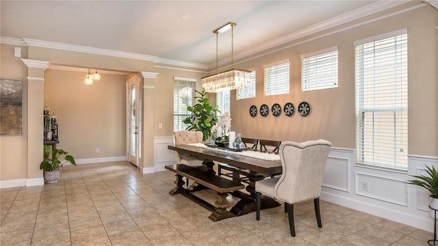 dining space featuring a wealth of natural light, a wainscoted wall, and crown molding