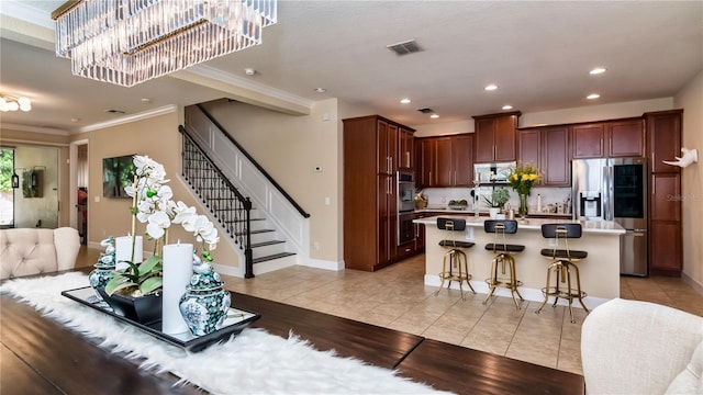 kitchen with light tile patterned floors, stainless steel appliances, light countertops, visible vents, and open floor plan