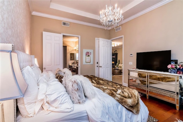 bedroom with a notable chandelier, visible vents, dark wood-style flooring, and a tray ceiling