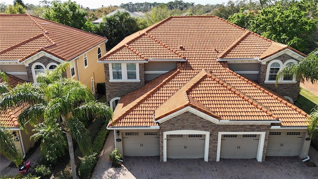 mediterranean / spanish house with a tiled roof and decorative driveway