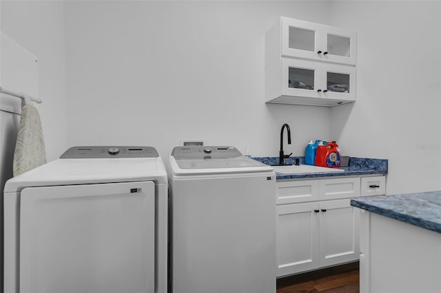 laundry room with dark wood finished floors, separate washer and dryer, a sink, and cabinet space