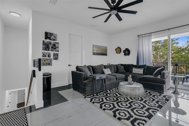 living area with marble finish floor, ceiling fan, visible vents, and baseboards