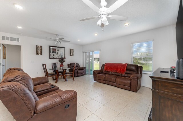 living room featuring a ceiling fan, light tile patterned flooring, visible vents, and recessed lighting