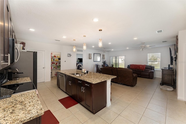 kitchen featuring dark brown cabinetry, visible vents, a kitchen island with sink, stainless steel appliances, and a sink