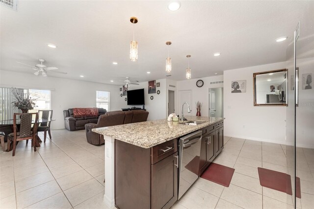 kitchen featuring light tile patterned flooring, dark brown cabinetry, a sink, visible vents, and dishwasher