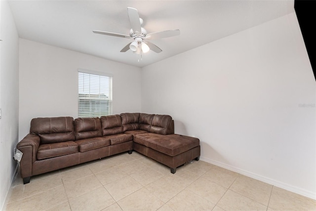 living room with light tile patterned floors, ceiling fan, and baseboards