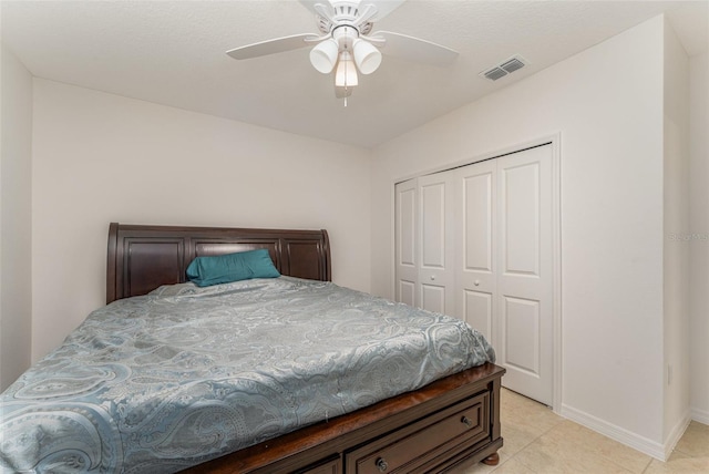 bedroom with baseboards, visible vents, a ceiling fan, a closet, and light tile patterned flooring