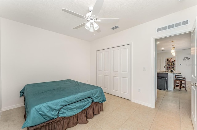 bedroom with light tile patterned floors, a closet, visible vents, and baseboards