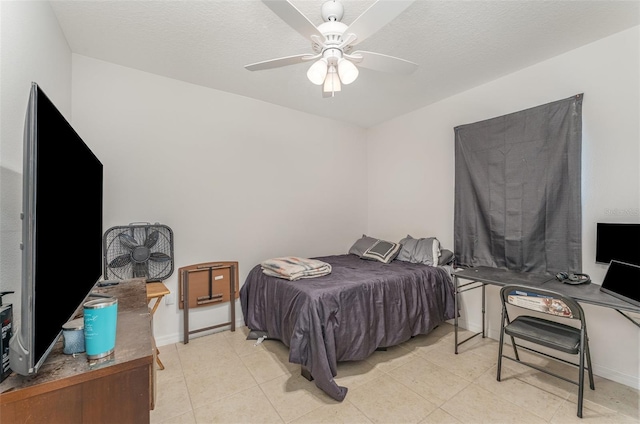 bedroom featuring a textured ceiling, light tile patterned flooring, a ceiling fan, and baseboards