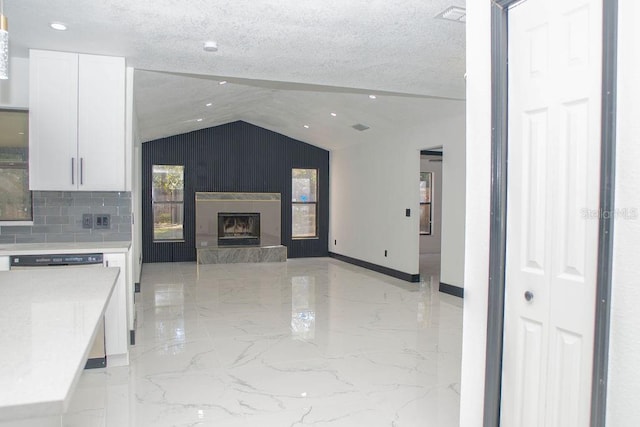 kitchen featuring a textured ceiling, marble finish floor, and white cabinets