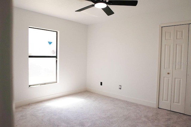 unfurnished bedroom featuring a closet, carpet flooring, ceiling fan, and baseboards