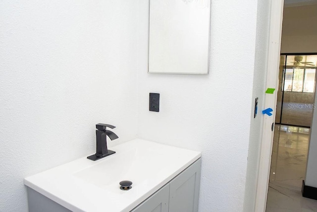 bathroom featuring a textured wall, marble finish floor, and vanity