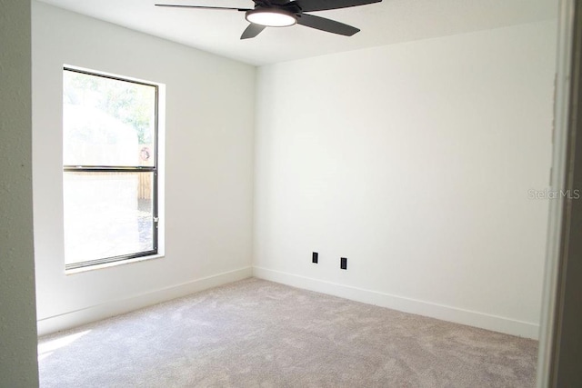 spare room with carpet flooring, a ceiling fan, and baseboards