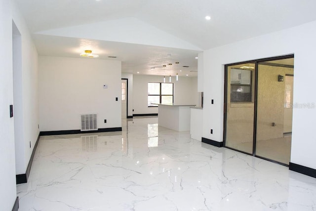 spare room featuring marble finish floor, visible vents, vaulted ceiling, and baseboards