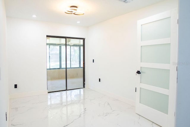 empty room featuring marble finish floor, recessed lighting, and baseboards