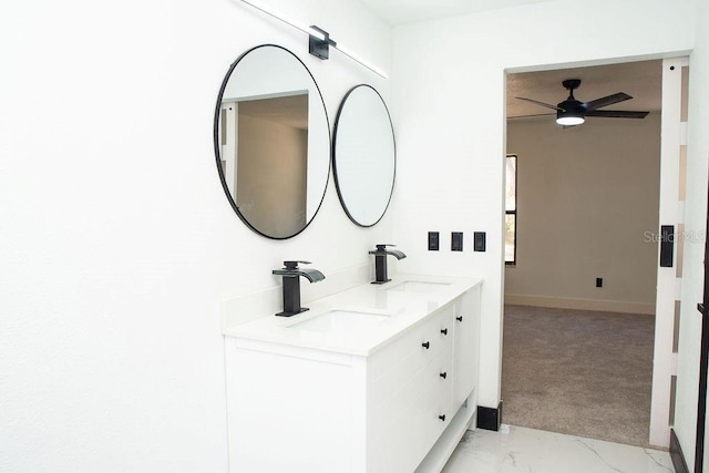 bathroom with marble finish floor, double vanity, a sink, and ceiling fan