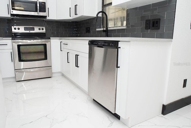 kitchen with white cabinetry, marble finish floor, tasteful backsplash, and appliances with stainless steel finishes