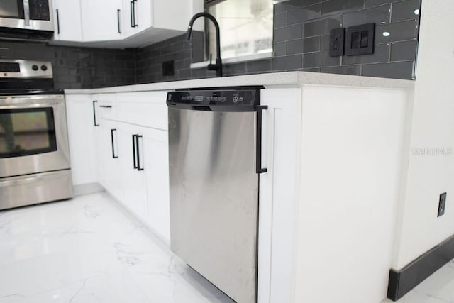 kitchen featuring marble finish floor, appliances with stainless steel finishes, white cabinetry, and tasteful backsplash