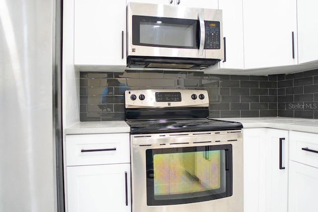 kitchen featuring appliances with stainless steel finishes, light countertops, white cabinetry, and decorative backsplash