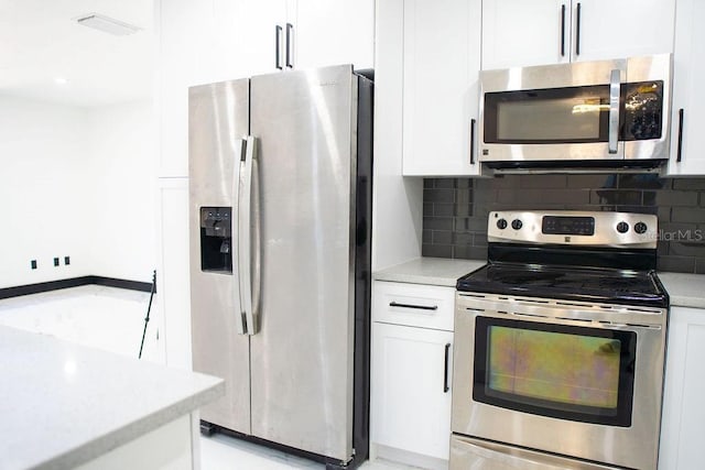 kitchen featuring appliances with stainless steel finishes, light countertops, white cabinets, and tasteful backsplash