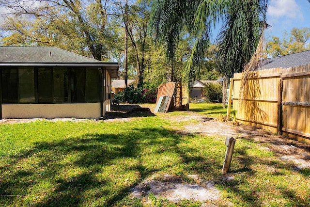 view of yard featuring a sunroom and fence