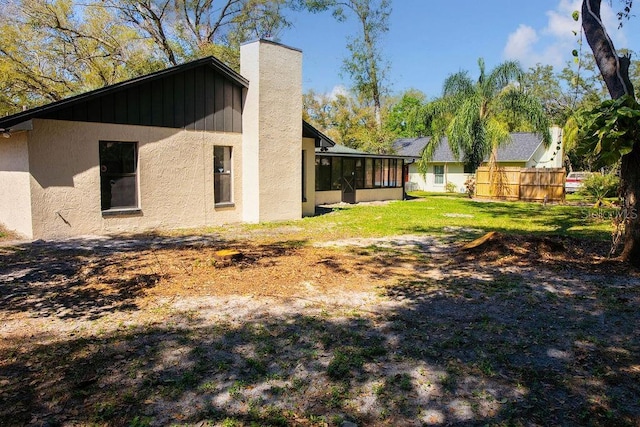 view of yard with a sunroom and fence