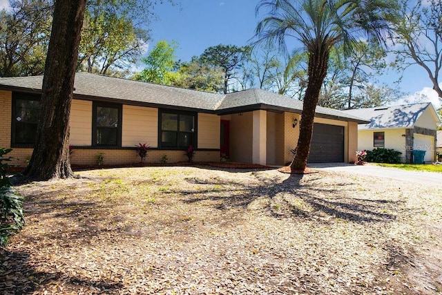 ranch-style home featuring a garage, driveway, and brick siding