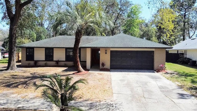 ranch-style house with a garage, brick siding, a shingled roof, concrete driveway, and a front yard