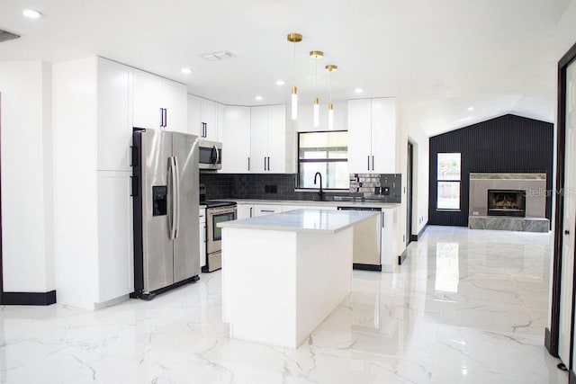 kitchen featuring visible vents, lofted ceiling, a kitchen island, appliances with stainless steel finishes, and marble finish floor