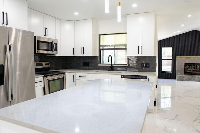 kitchen featuring marble finish floor, appliances with stainless steel finishes, plenty of natural light, and a sink