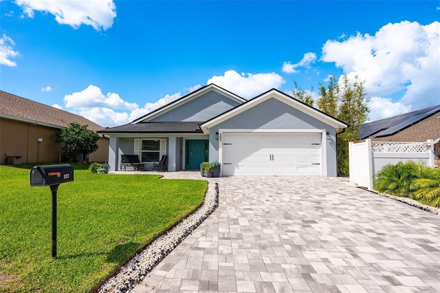 ranch-style home with a garage, fence, decorative driveway, a front lawn, and stucco siding