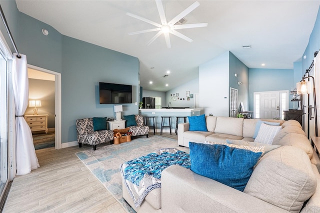 living area with baseboards, visible vents, wood finished floors, high vaulted ceiling, and recessed lighting