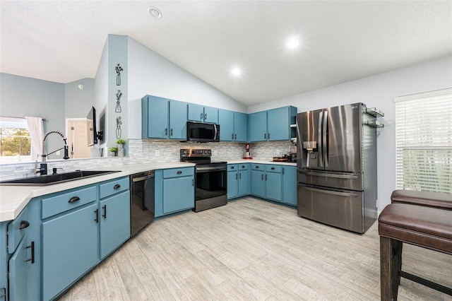 kitchen featuring blue cabinets, appliances with stainless steel finishes, light countertops, and a sink