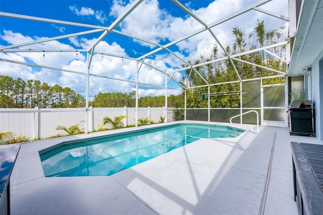 view of pool featuring glass enclosure, a patio area, a fenced backyard, and a grill