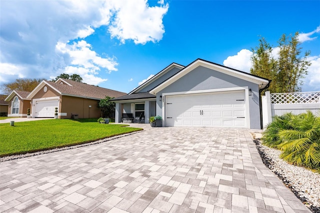 ranch-style house with a garage, stucco siding, fence, decorative driveway, and a front yard