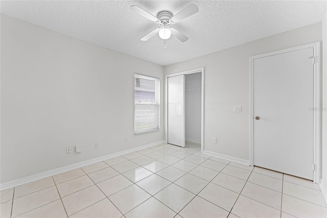 unfurnished bedroom featuring a textured ceiling, a closet, a ceiling fan, and baseboards