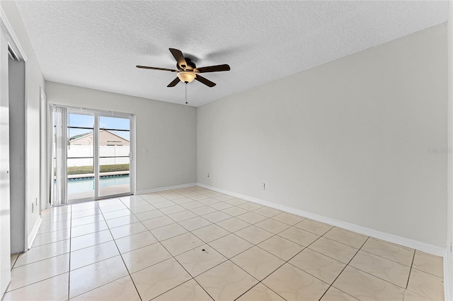 spare room featuring a ceiling fan, a textured ceiling, baseboards, and light tile patterned floors