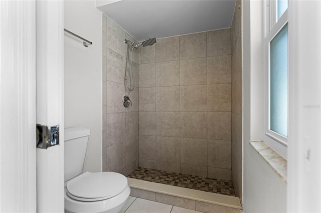 full bath with tile patterned flooring, a tile shower, and toilet