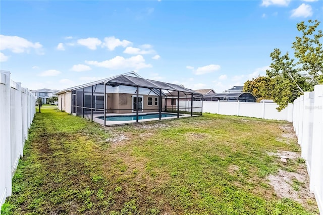 rear view of house with a yard, a fenced backyard, and a lanai