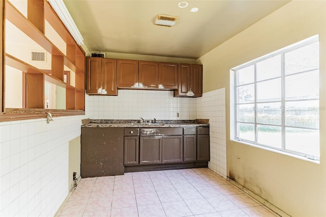 kitchen featuring tasteful backsplash, visible vents, a sink, and light tile patterned floors