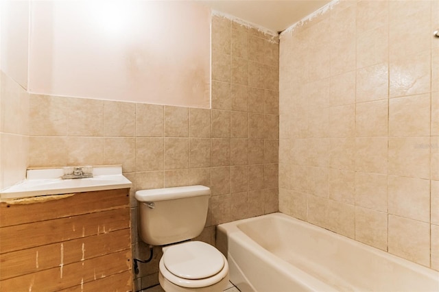 bathroom with vanity, tile walls, toilet, and a bathing tub