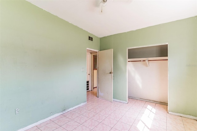 unfurnished bedroom with baseboards, visible vents, a ceiling fan, tile patterned floors, and a closet