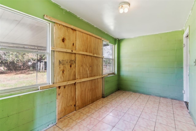 unfurnished room featuring concrete block wall