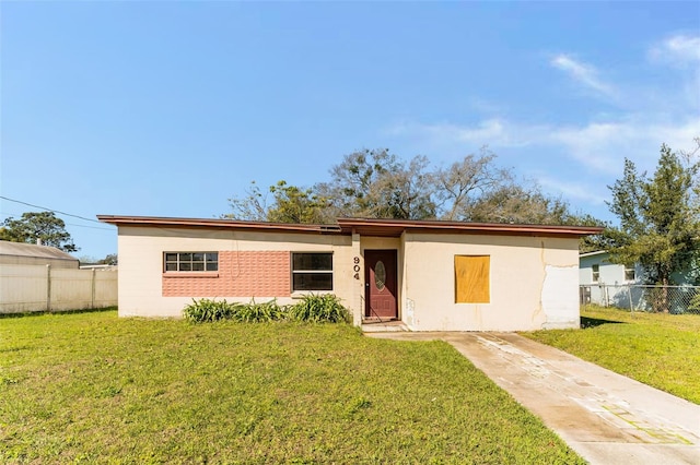 single story home with a front yard and fence