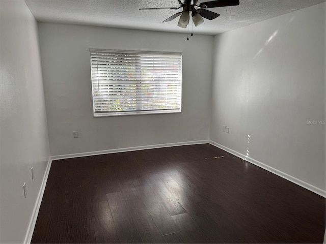 empty room with dark wood-style floors, a textured ceiling, baseboards, and a ceiling fan