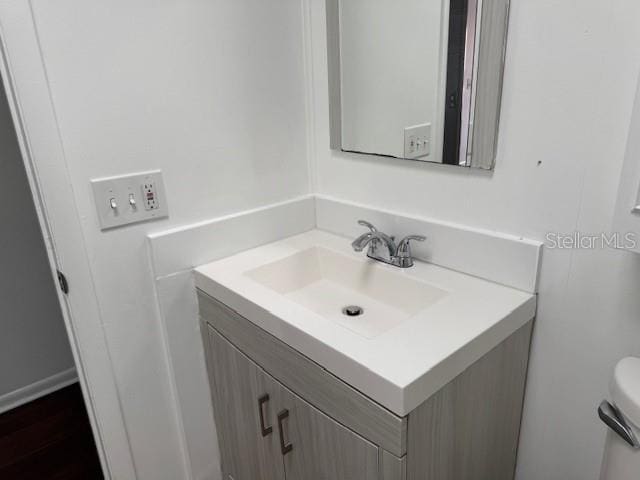 half bath featuring toilet and vanity