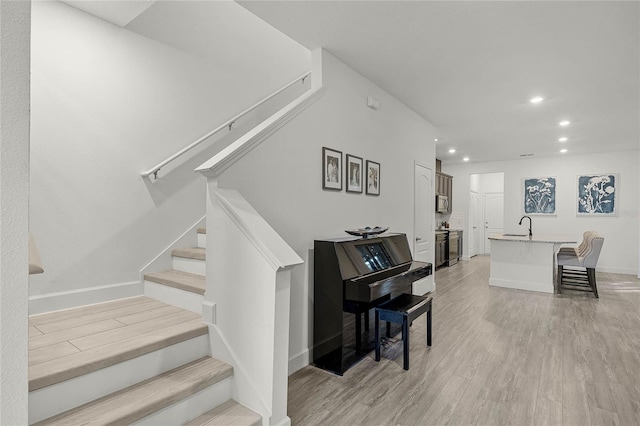 staircase with recessed lighting, baseboards, and wood finished floors