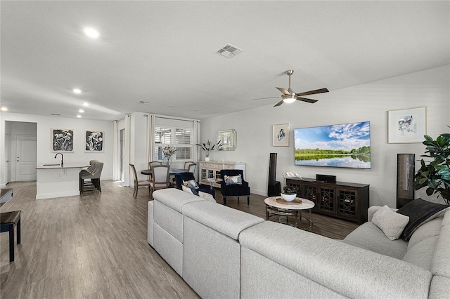 living area with recessed lighting, visible vents, ceiling fan, wood finished floors, and baseboards