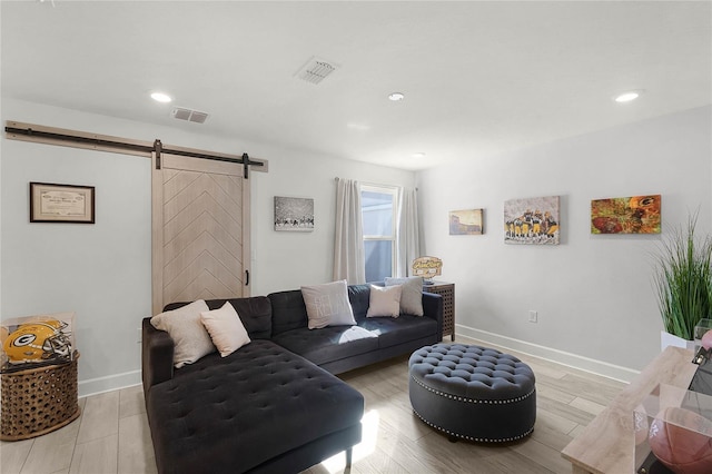 living room featuring visible vents, baseboards, and a barn door